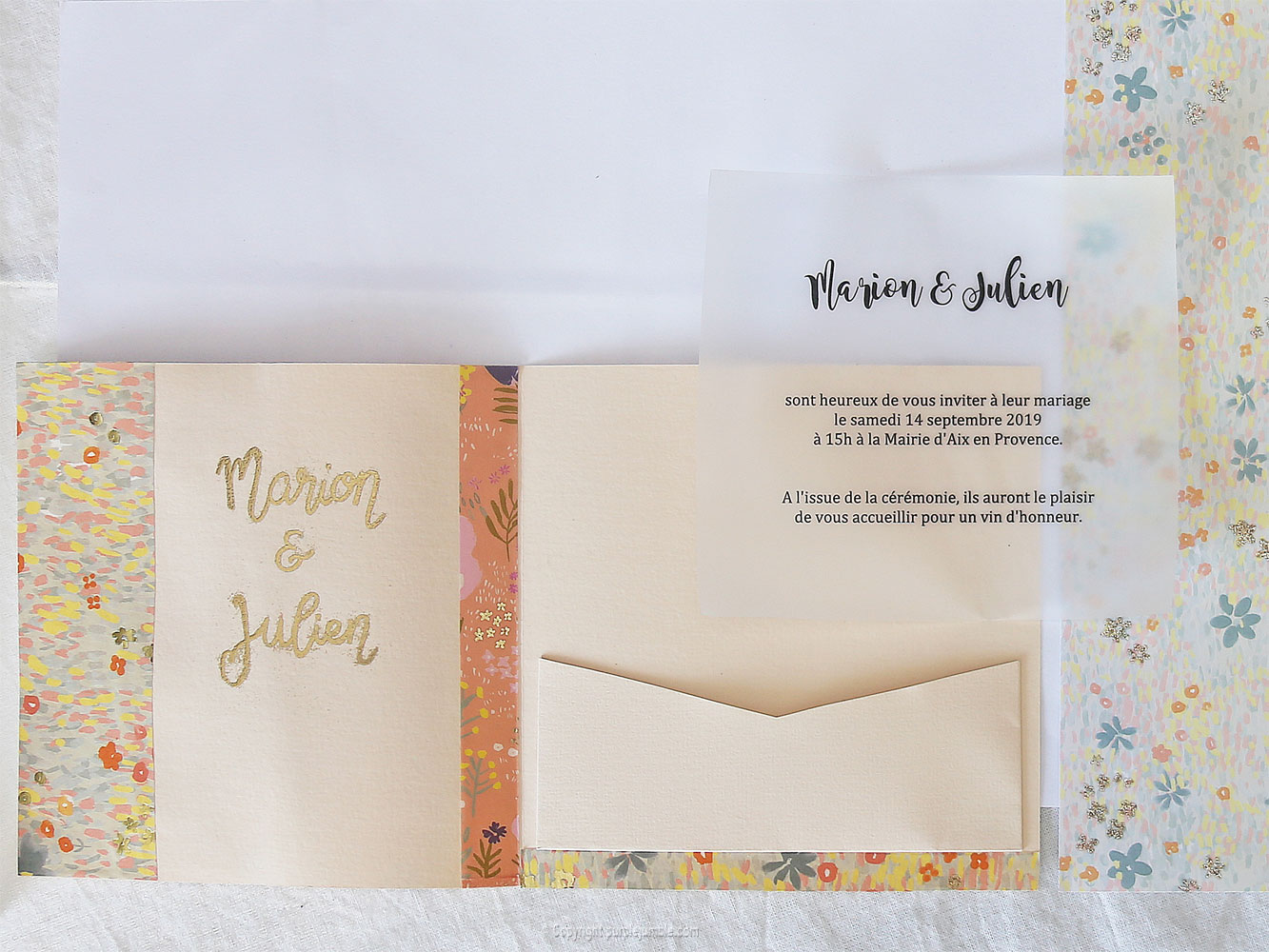 Une invitation de mariage et une enveloppe décorées avec du papier